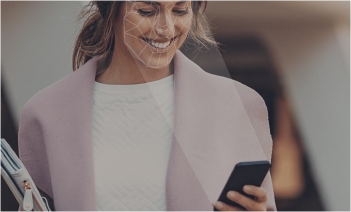 image of woman holding smart phone projecting biometric lines on face.