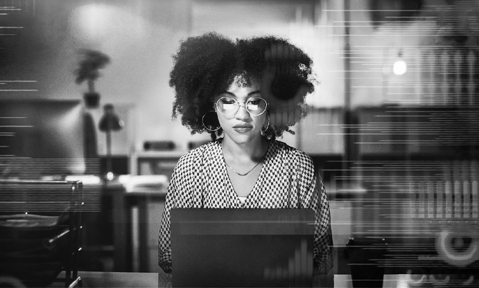 woman sitting at desk wearing glasses.